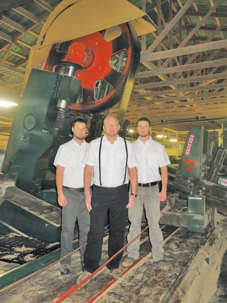 From left, Josh, Paul and Jeremy Peachey are seen in front of the 7-foot McDonough headrig.