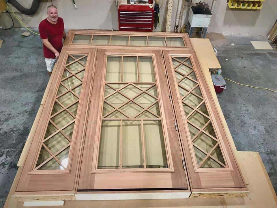 Team member Jim Heatley inspects a newly finished exterior door at Millwork 360, located in Tampa, FL.