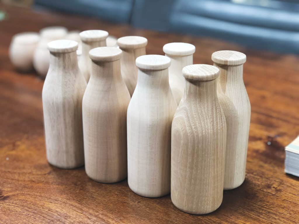 Crafted Elements fashions milk bottles out of wood.