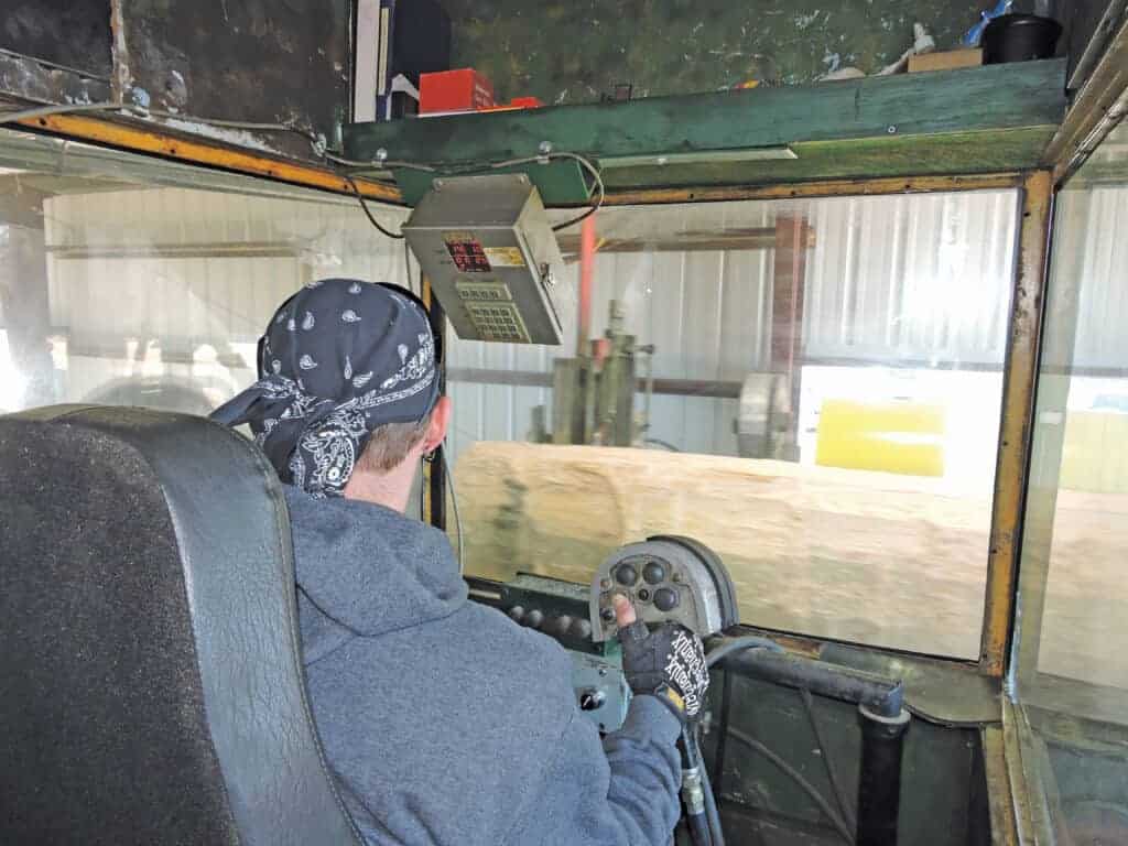 Cody Gray works in the cab at Prime Lumber Sawmill to control the precision-sawing of lumber.