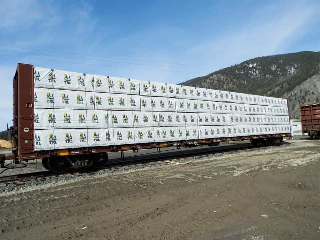 A rail car is loaded to the max with high-quality lumber, carrying the Thompson River Lumber logo.