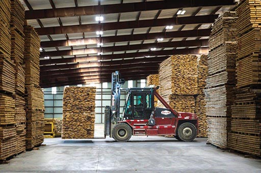 Hardwood packs are moved in the distribution center.